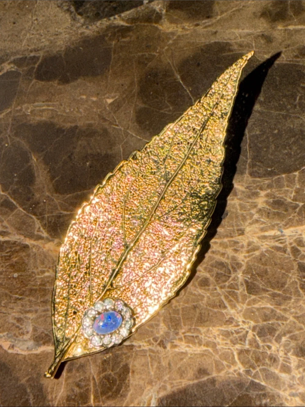 Beautiful gold plated leaf with a cabochon opal and crystal surrounding
